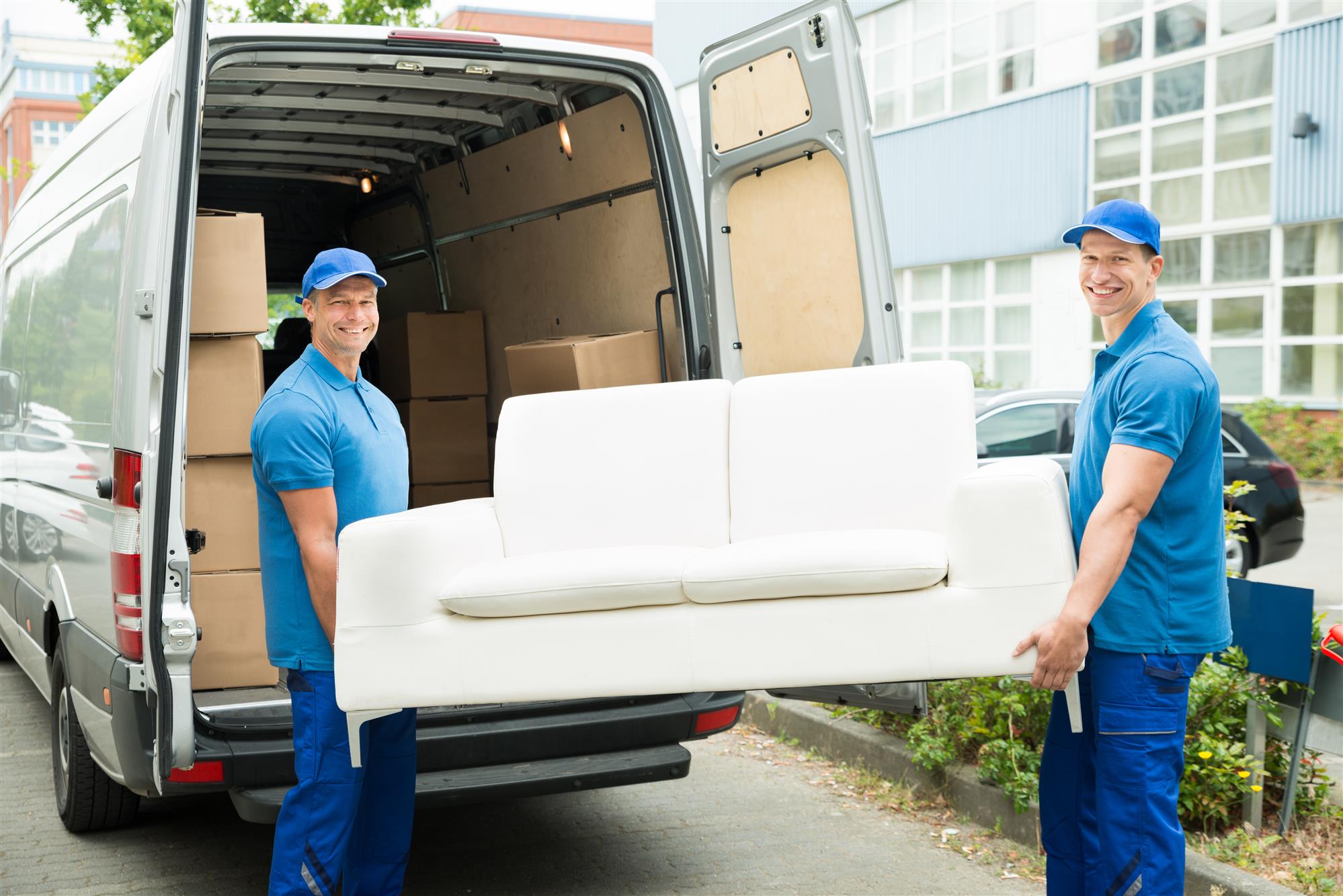 male workers putting furniture in truck