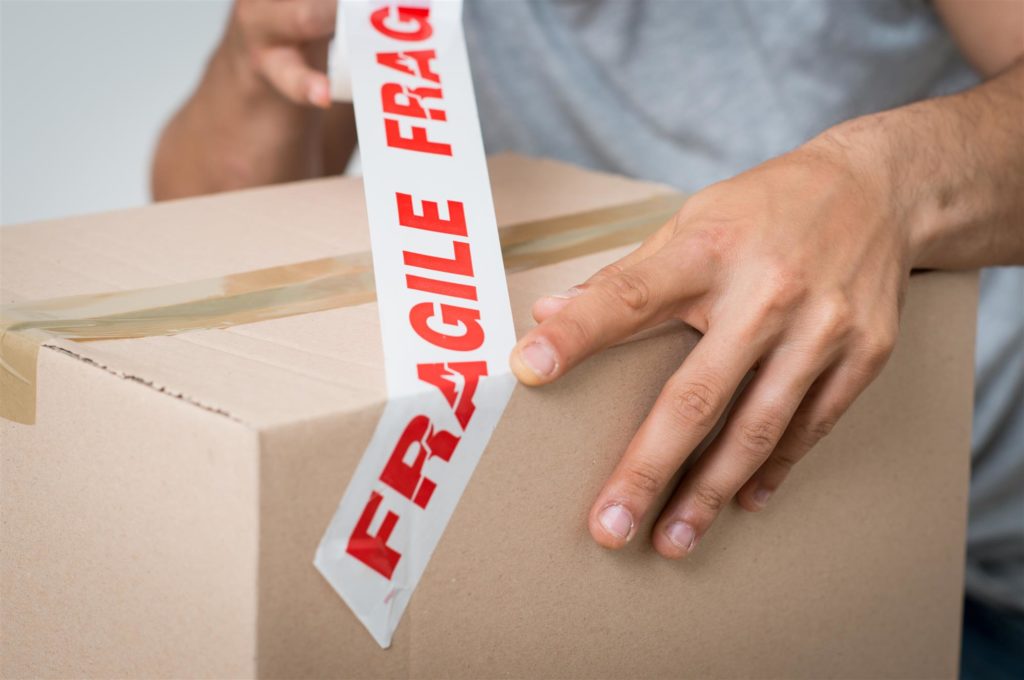 man taping cardboard box