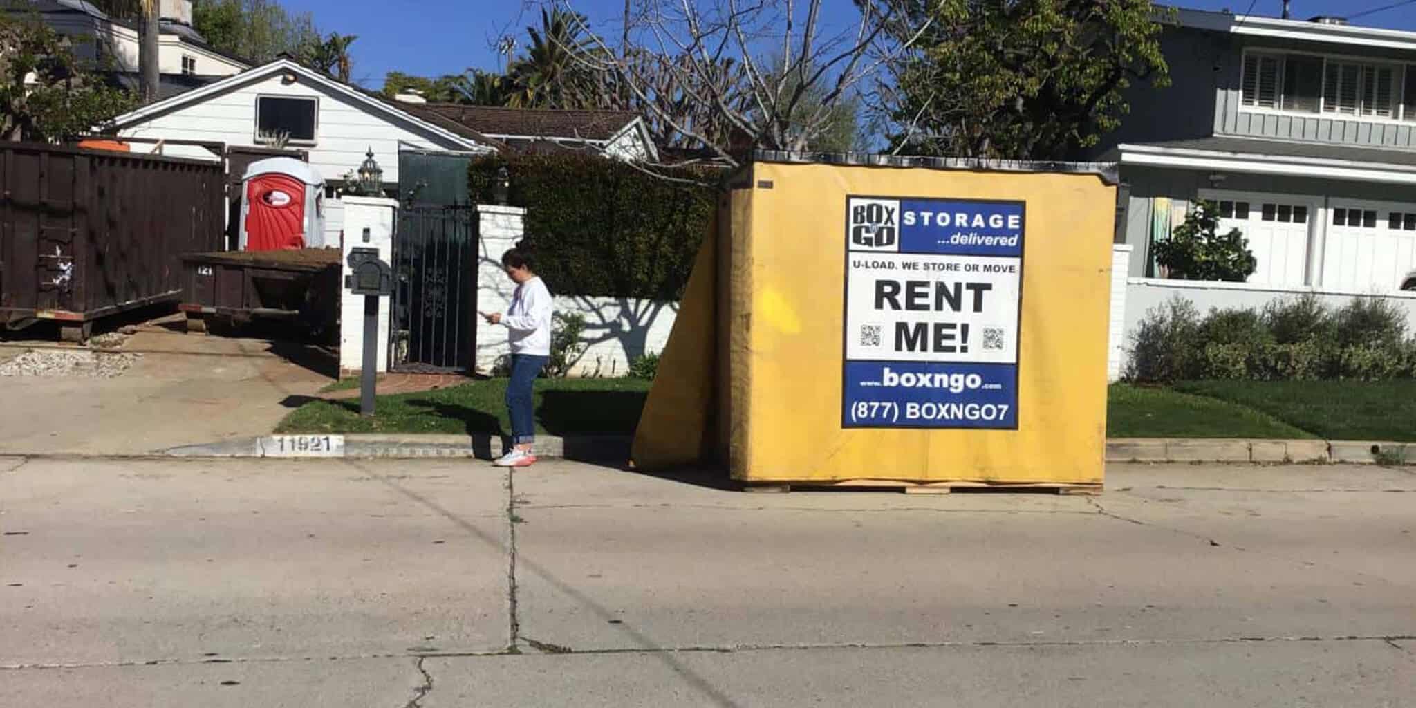 Box-n-Go storage container and woman on sidewalk in front of a Mid-City, Los Angeles home.