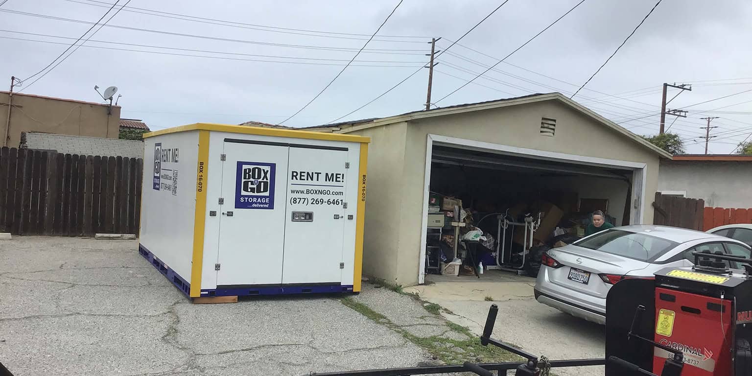 portable storage containers labeled "Box Go Storage" beside the garage in Los Angeles.