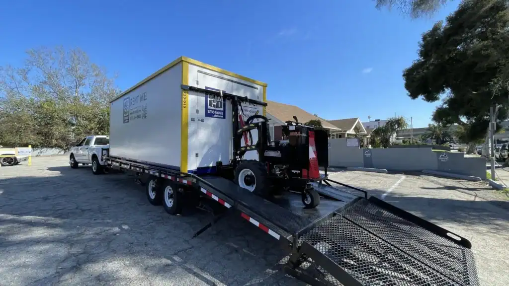 Box-n-Go portable container being delivered for office inventory storage in West Hollywood, showing a forklift unloading from a flatbed truck in a residential-commercial area.