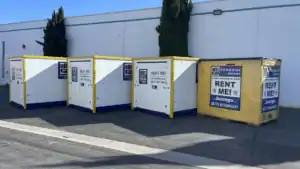 Box-n-Go portable storage units lined up outside a facility, ready for pickup by professional movers that load containers for storage or relocation.