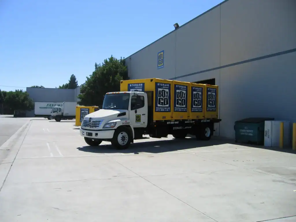 Box-n-Go self storage truck outside a warehouse facility providing portable self storage in Florence-Graham CA, with mobile storage containers ready for delivery.