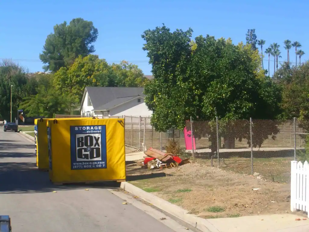 Bright yellow portable storage containers from Box-n-Go on a residential street in Paramount, CA, showcasing convenient self storage in Paramount CA for local moving and storage needs.