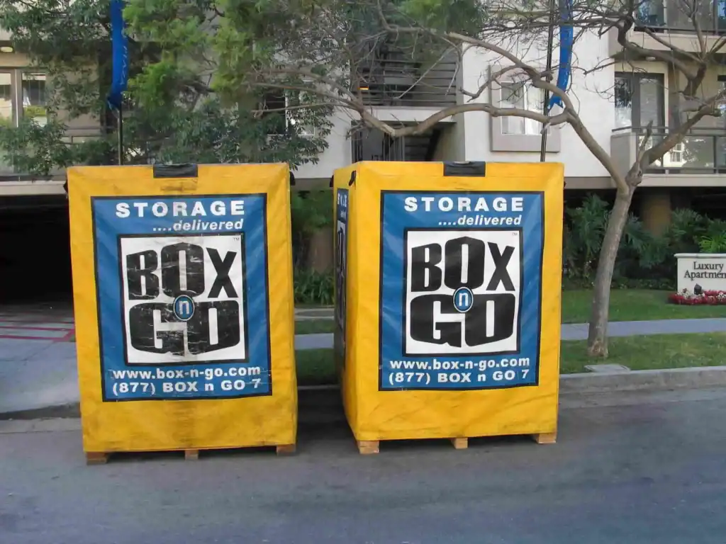 Convenient Self Storage in Monterey Park CA with portable Box-n-Go storage containers placed outside apartment buildings for easy moving and storage solutions.