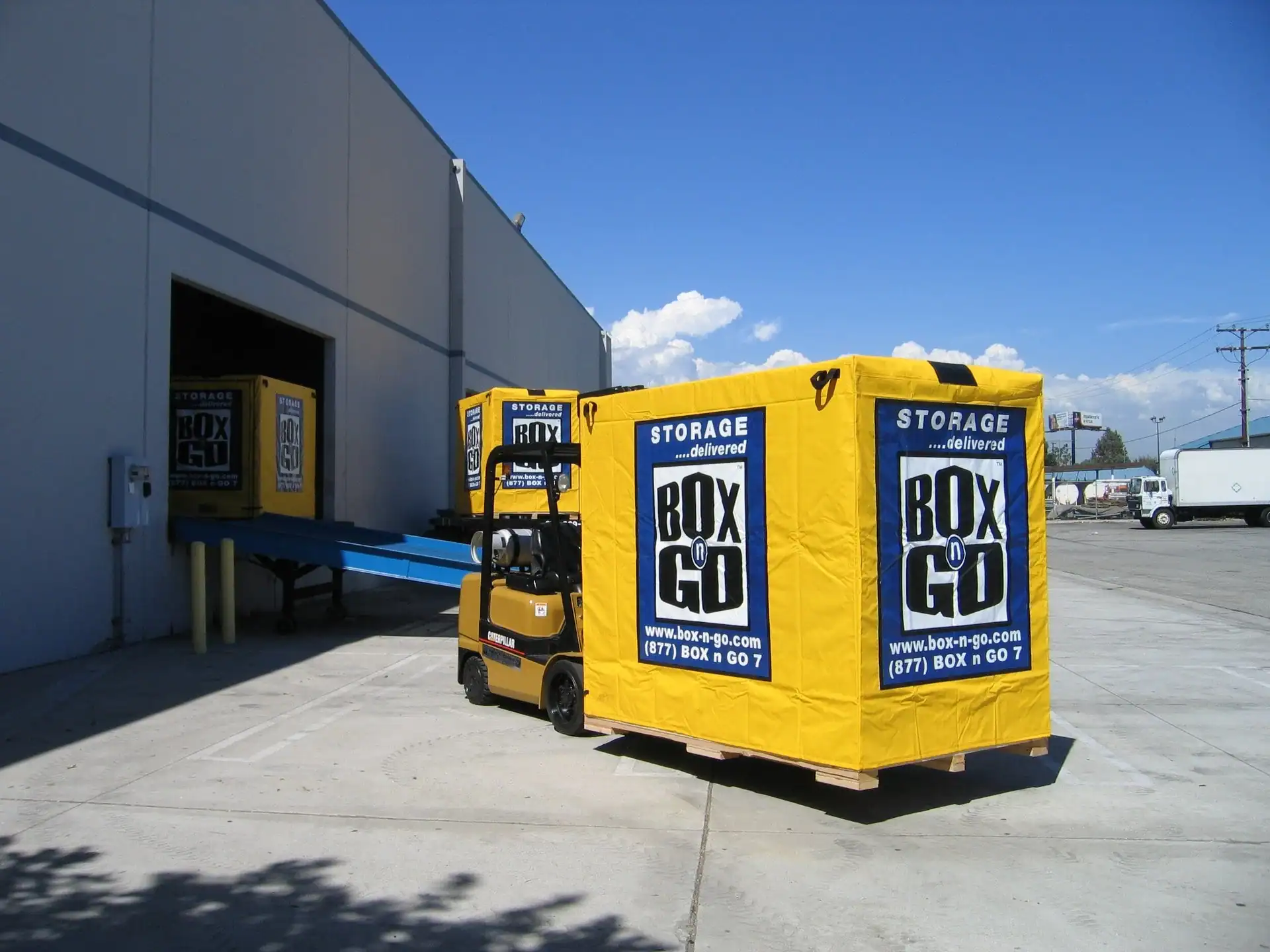 Forklift moving a Box-n-Go portable storage unit into a warehouse facility, providing secure and affordable long term storage solutions for households, students, and businesses.