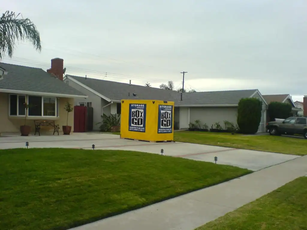 Garage rental space with a storage container on a driveway, offering a convenient option for storing belongings. The storage container is branded with BoxGo, providing a mobile storage solution for homeowners in need of extra space.