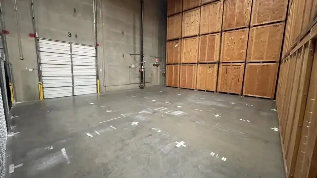 Indoor warehouse facility storing wooden moving containers stacked securely, ideal for long-term or short-term storage during relocation or home remodeling projects.