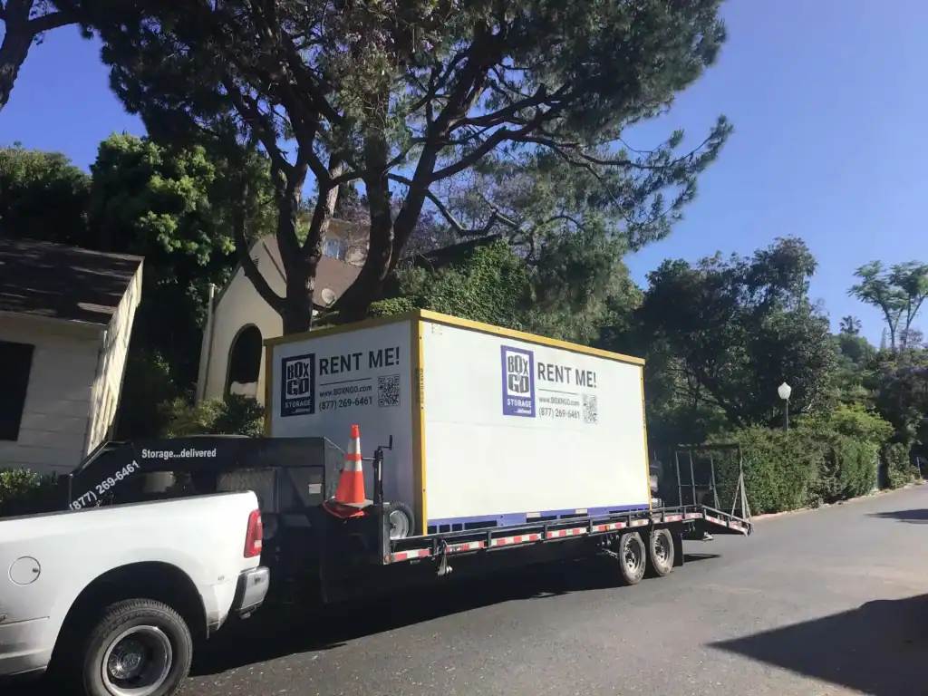 Portable self storage in Lynwood CA – BOX-n-Go storage container on a trailer ready for delivery to a residential neighborhood, offering convenient and secure storage rental solutions.