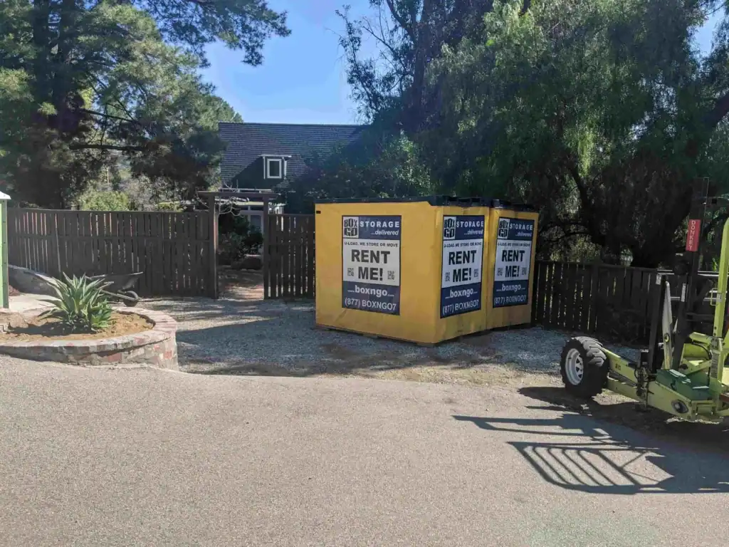 Portable yellow storage containers from Box-n-Go placed outside a residential property, ideal for convenient and flexible Self Storage in Downey CA.