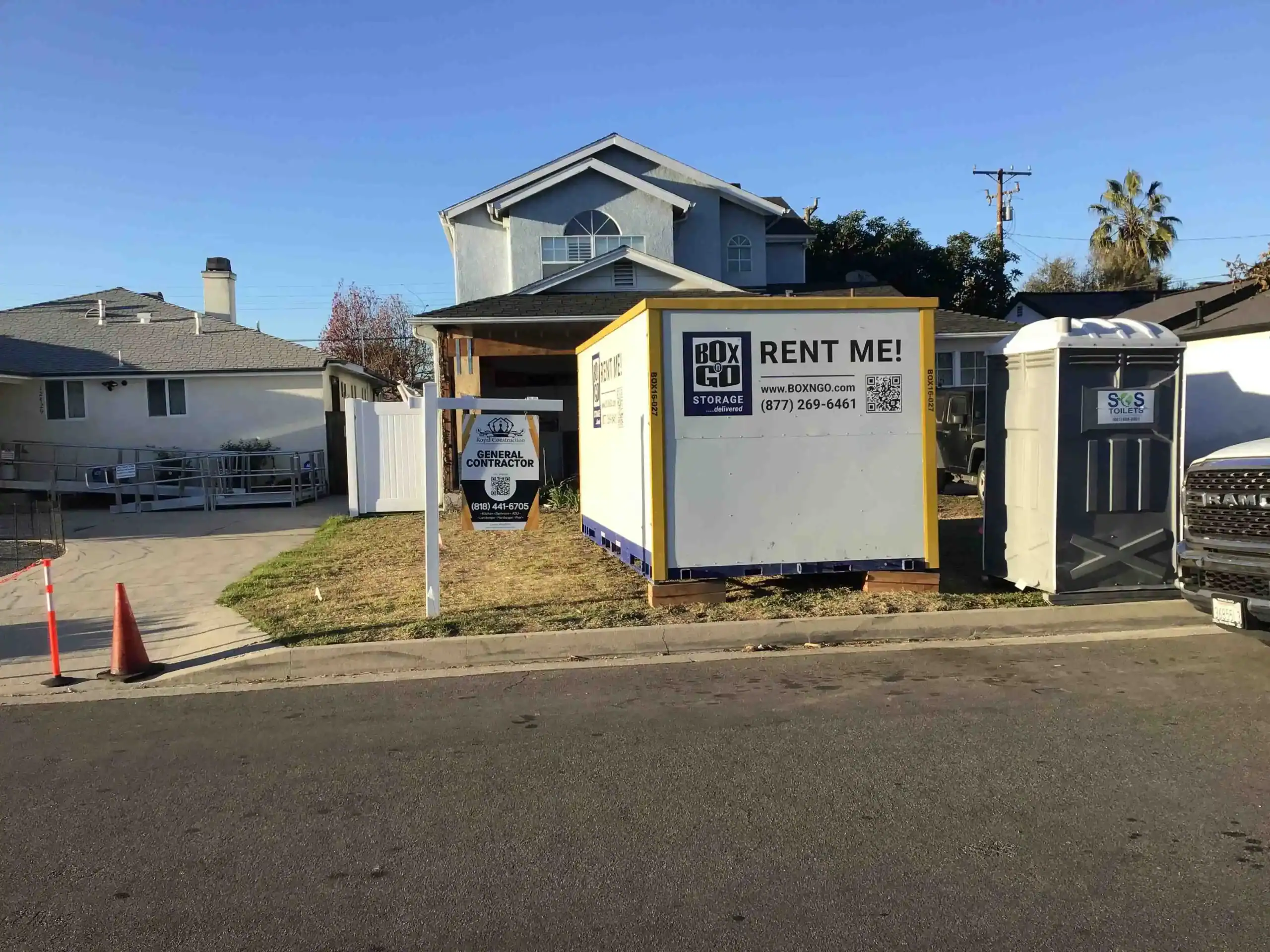 Residential construction site in Santa Monica with a Box-n-Go portable unit used for office inventory storage, featuring a contractor sign and portable restroom on the front lawn.