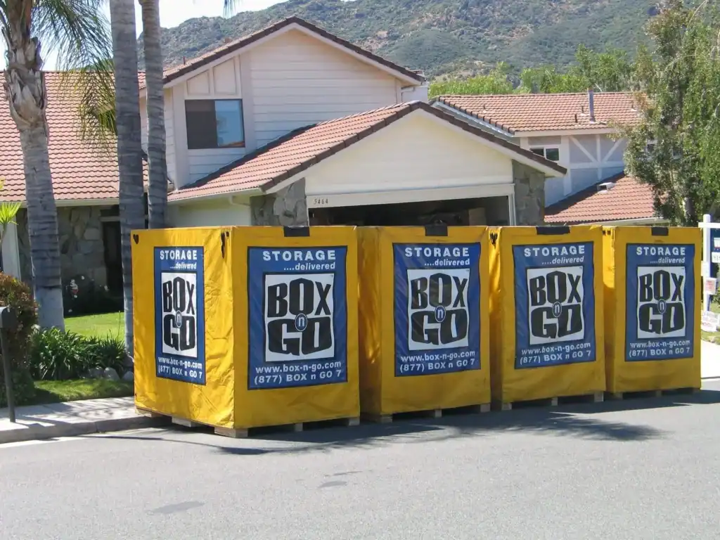 Residential property with multiple Box-n-Go portable storage containers placed in front of the garage, ideal for those seeking flexible garage rental space.