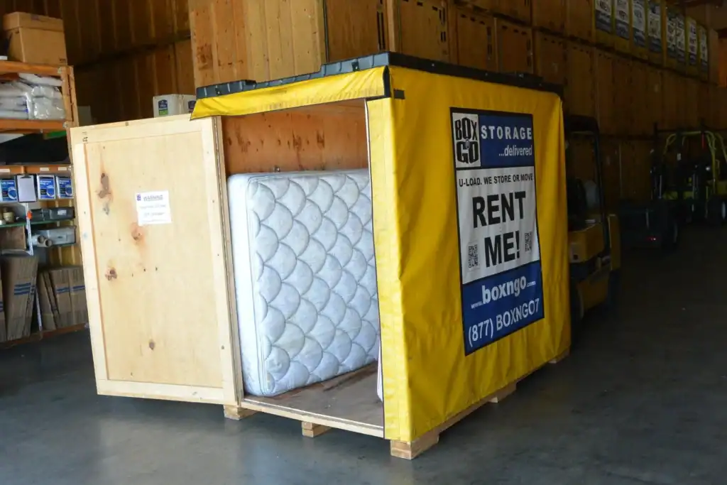 Secure home renovation storage solution with a Box-n-Go portable storage unit inside a warehouse, containing a mattress and personal items, ideal for decluttering during remodeling projects.