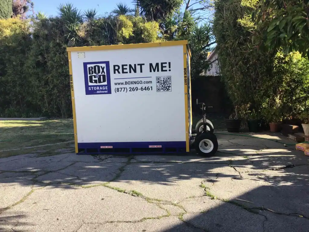 Self storage in Lynwood CA with a BOX-n-Go portable storage container placed in a residential driveway, offering easy and affordable storage rental solutions.
