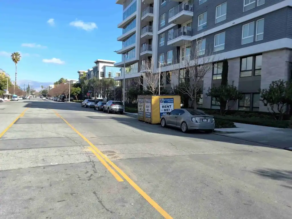 Street view of an apartment complex in Topanga featuring a storage unit container labeled 'Rent Me'. Ideal for those looking for Storage Units in Topanga for easy access and convenient storage solutions.