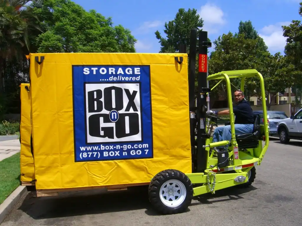 Worker using a forklift to deliver a Box-n-Go portable storage unit, providing secure and flexible long term storage options for homes, students, and businesses.