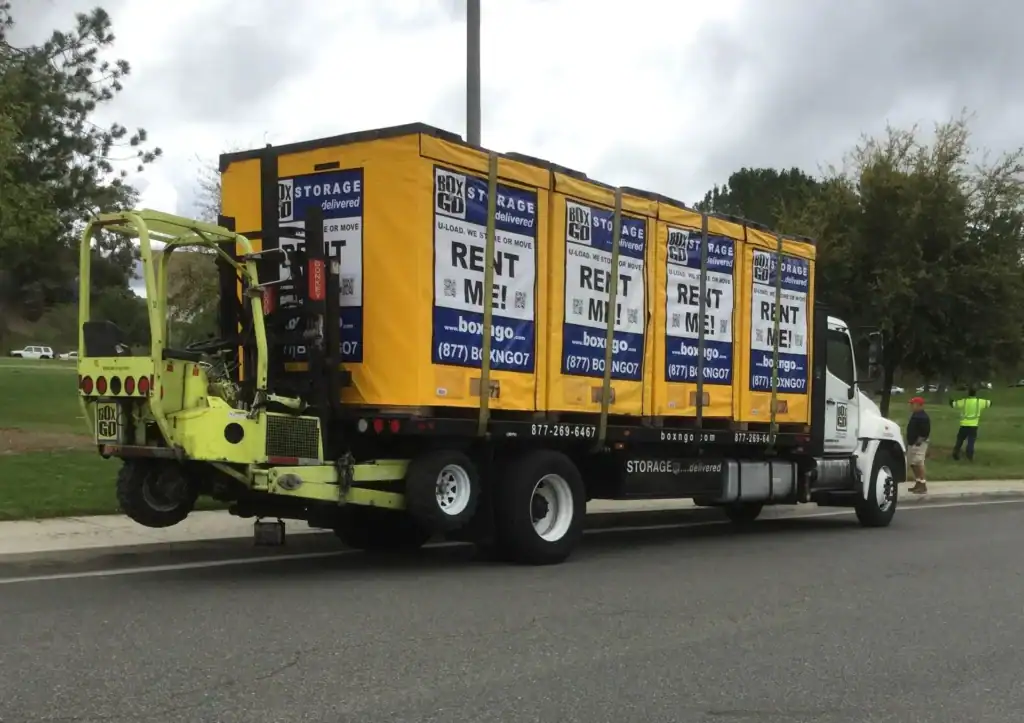 Box-n-Go delivery truck transporting multiple portable storage containers, ideal for trade show booth storage, offering secure and convenient solutions for event setup and logistics.