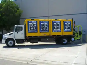 Box-n-Go moving truck loaded with portable storage containers, showcasing services from affordable local moving companies that provide convenient and cost-effective relocation solutions.