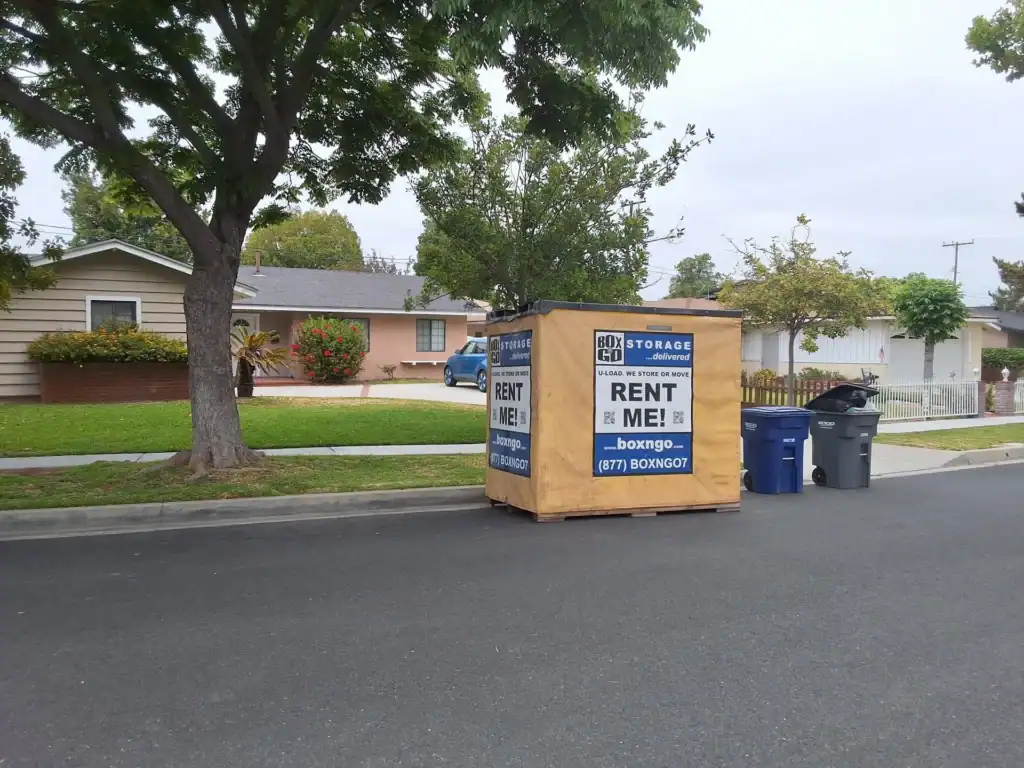 Box-n-Go portable storage container placed on a residential street, promoting convenient moving and storage services with flexible rental options for homeowners.