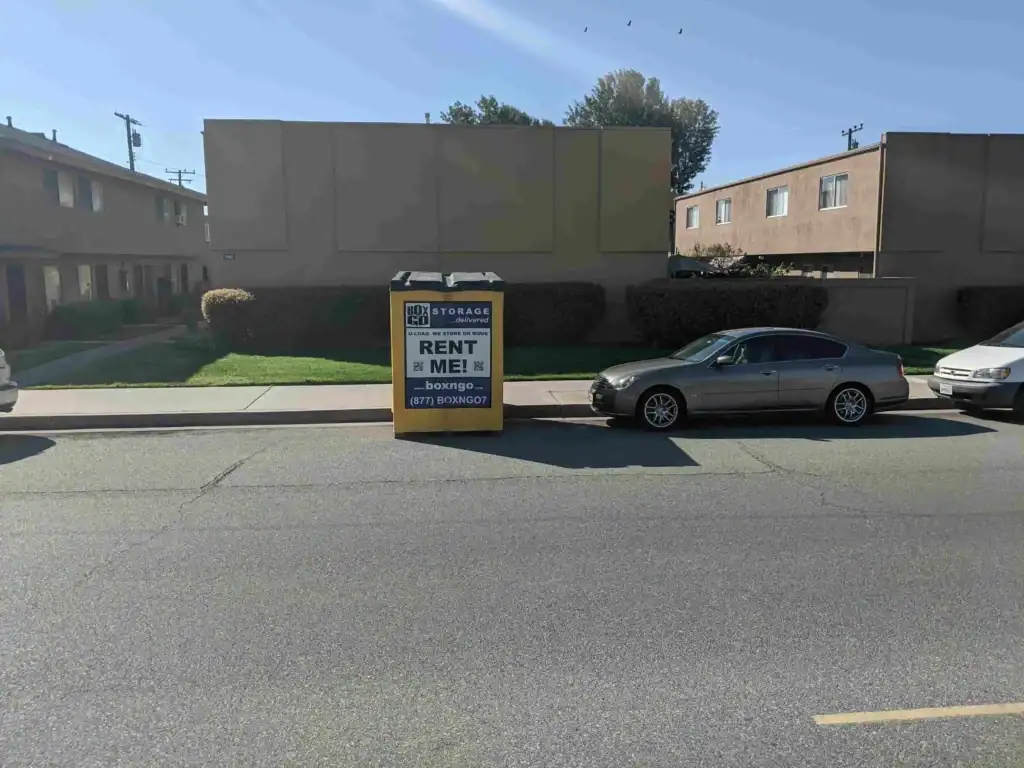 Box-n-Go portable storage unit placed on a residential street with parked cars, representing convenient moving and storage solutions from a trusted local moving company in Sherman Oaks.
