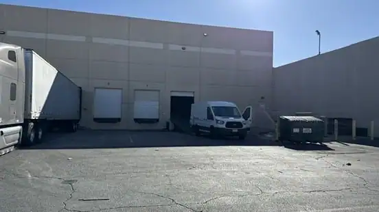Commercial loading dock area in Sherman Oaks with delivery trucks and vans, showing a potential site for portable storage Sherman Oaks solutions for business logistics and warehouse needs.