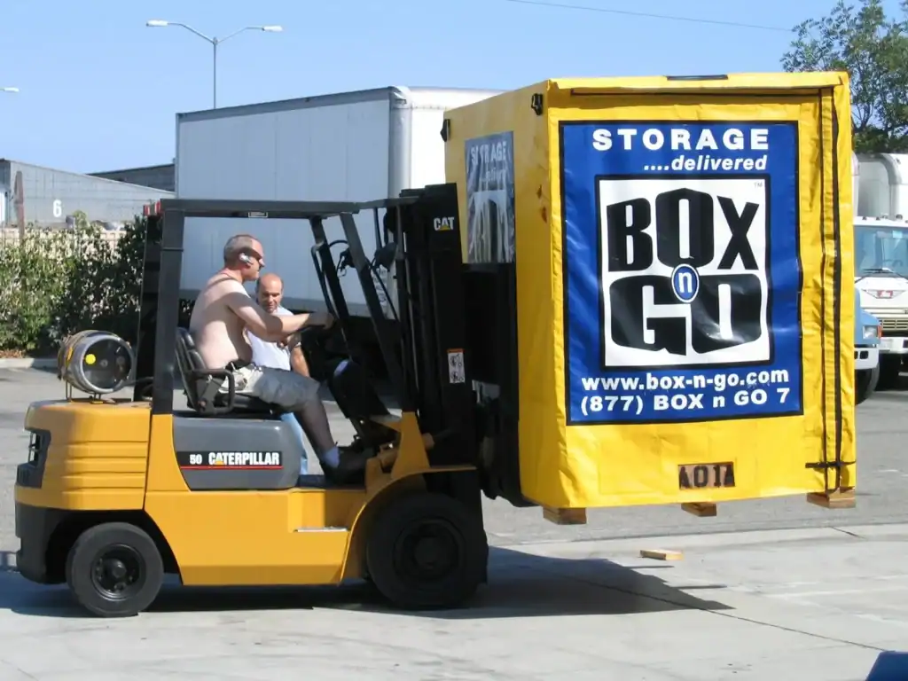 Forklift transporting a Box-n-Go portable storage unit at a warehouse facility, representing reliable and secure long term storage in Sherman Oaks for residential and business use.