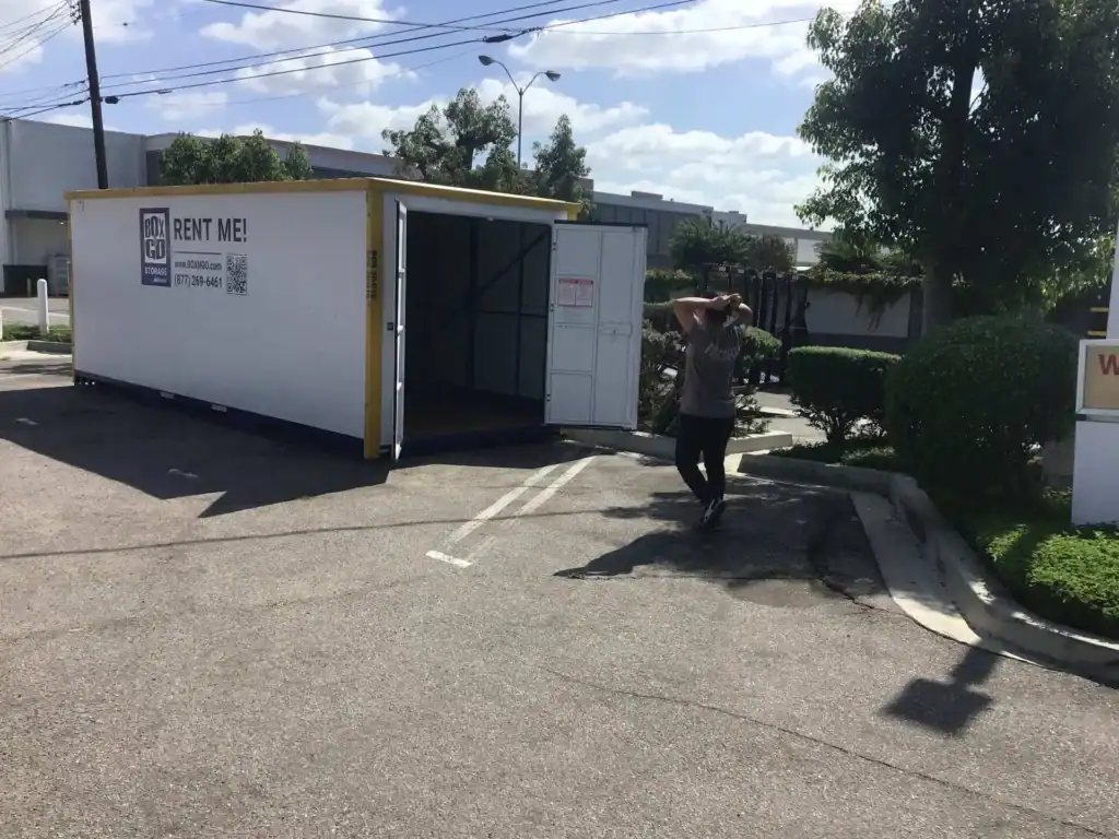 Large Box-n-Go portable storage unit with open doors in a parking lot, promoting storage container rental in West Hollywood for convenient moving and secure storage solutions.