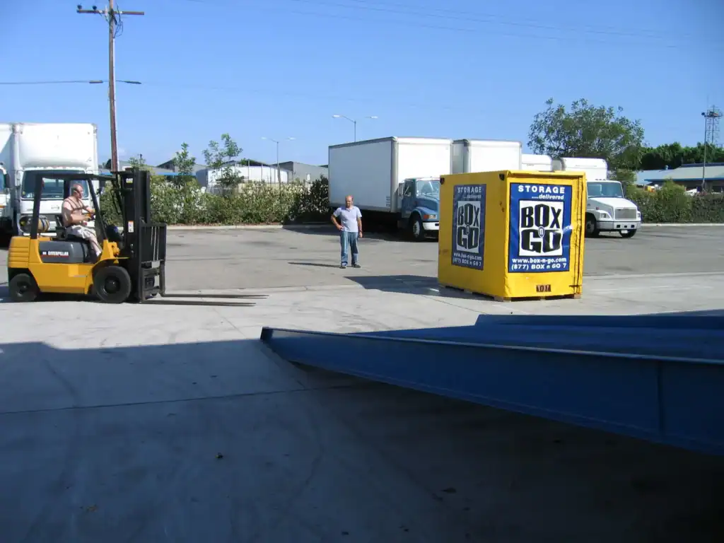 Moving and storage services Encino – forklift operator preparing portable storage container for transport at a secure storage facility, ideal for residential and commercial moving solutions.