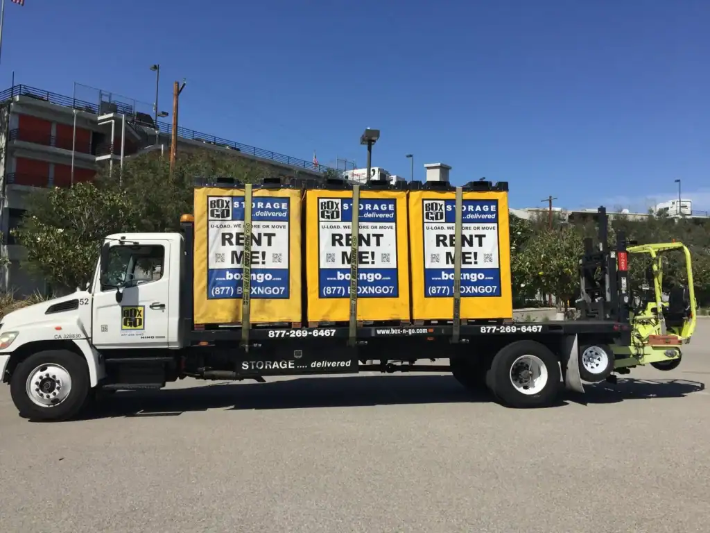 Portable storage units in Santa Monica from Box n Go, delivered directly to your location. The image shows a truck carrying multiple yellow storage containers, highlighting the flexibility and convenience of portable storage solutions in Santa Monica. Box n Go offers rental services for on-demand storage and moving.