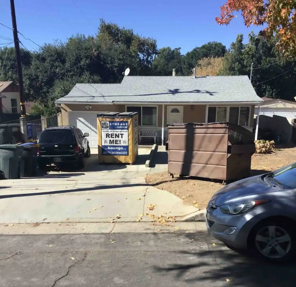 Self Storage Unit in Agua Dulce, CA – A BoxGo portable storage container for rent, positioned in front of a residential home with a dumpster in the driveway. Ideal for anyone seeking a convenient and secure self-storage solution in Agua Dulce, CA.
