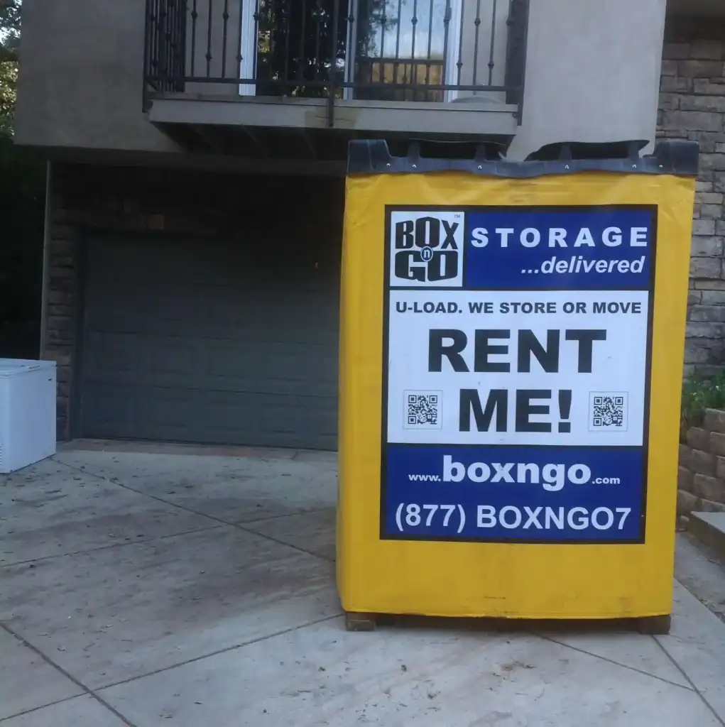 Yellow Box-n-Go portable storage container placed in front of a residential garage, showcasing convenient and reliable self storage in Arleta CA for homeowners needing temporary or long-term storage solutions.