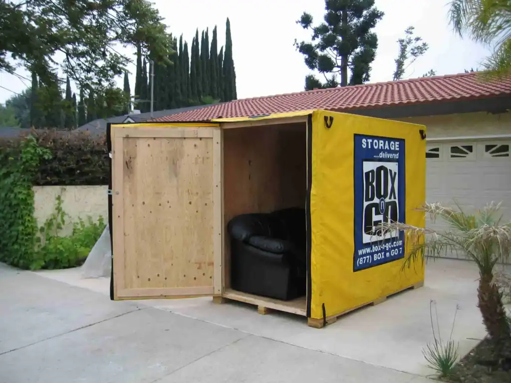 Self Storage Montrose Portable storage Montrose container placed in a residential driveway with an open Box-n-Go unit showing furniture stored safely inside.