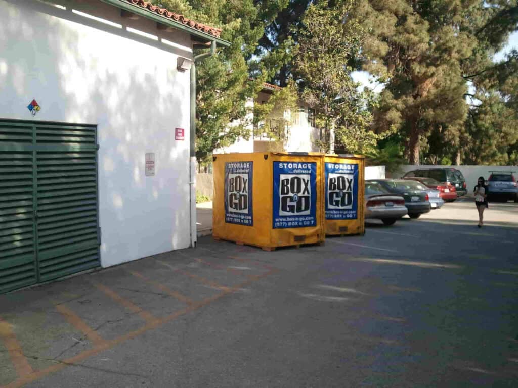 Portable Storage Reseda Portable storage Reseda units from Box-n-Go placed in a parking area beside a white building, offering convenient on-site storage solutions for residents and businesses in Reseda.