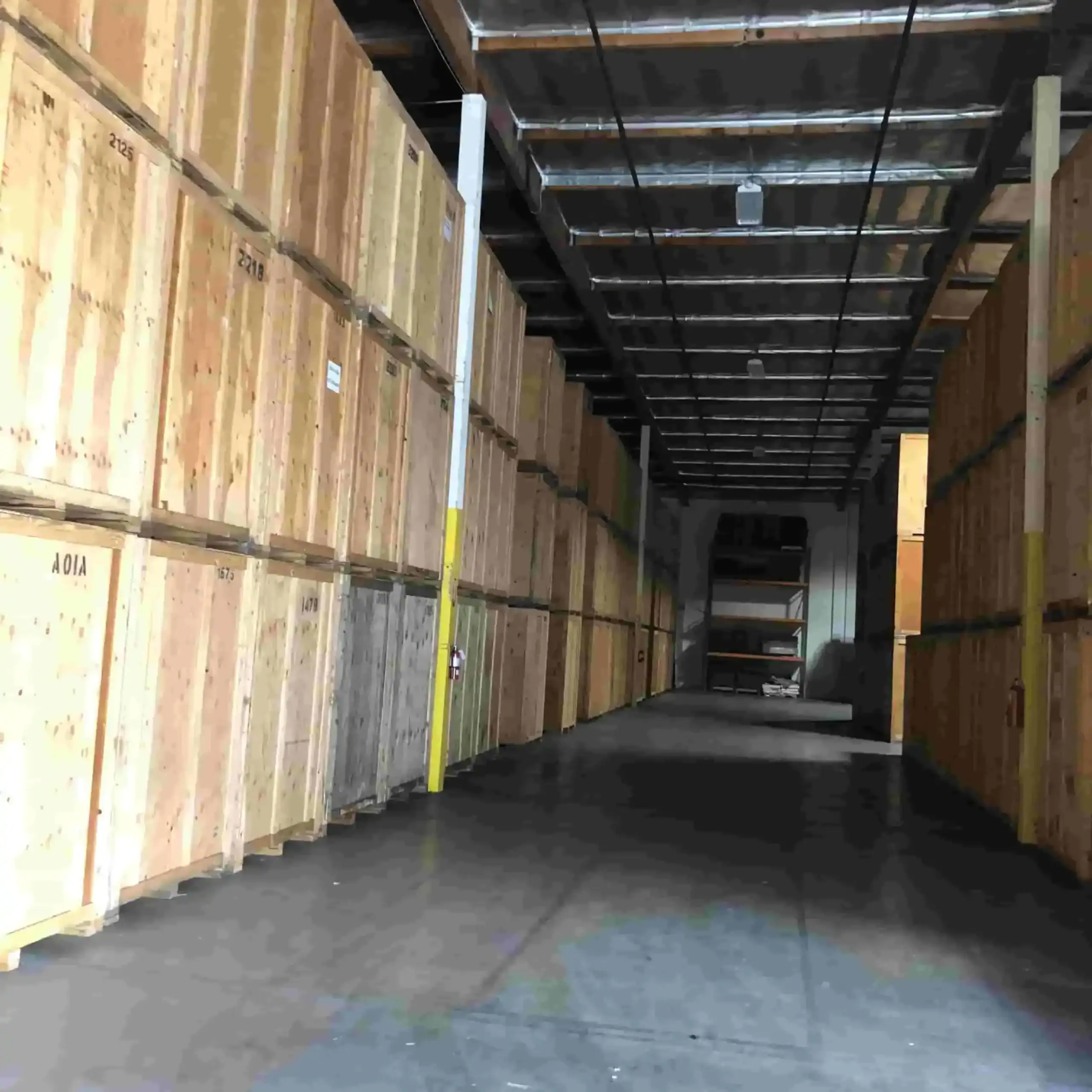 Secure Self Storage Montrose CA Secure warehouse filled with neatly stacked wooden storage vaults used for portable storage Montrose services, showing organized indoor storage space.