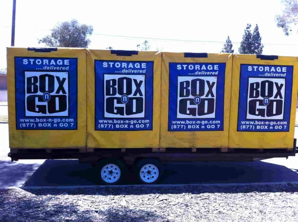 Portable yellow Box-n-Go storage containers lined up on a trailer for convenient self-storage-Valley-Village services, offering easy, mobile storage solutions for homes and businesses.