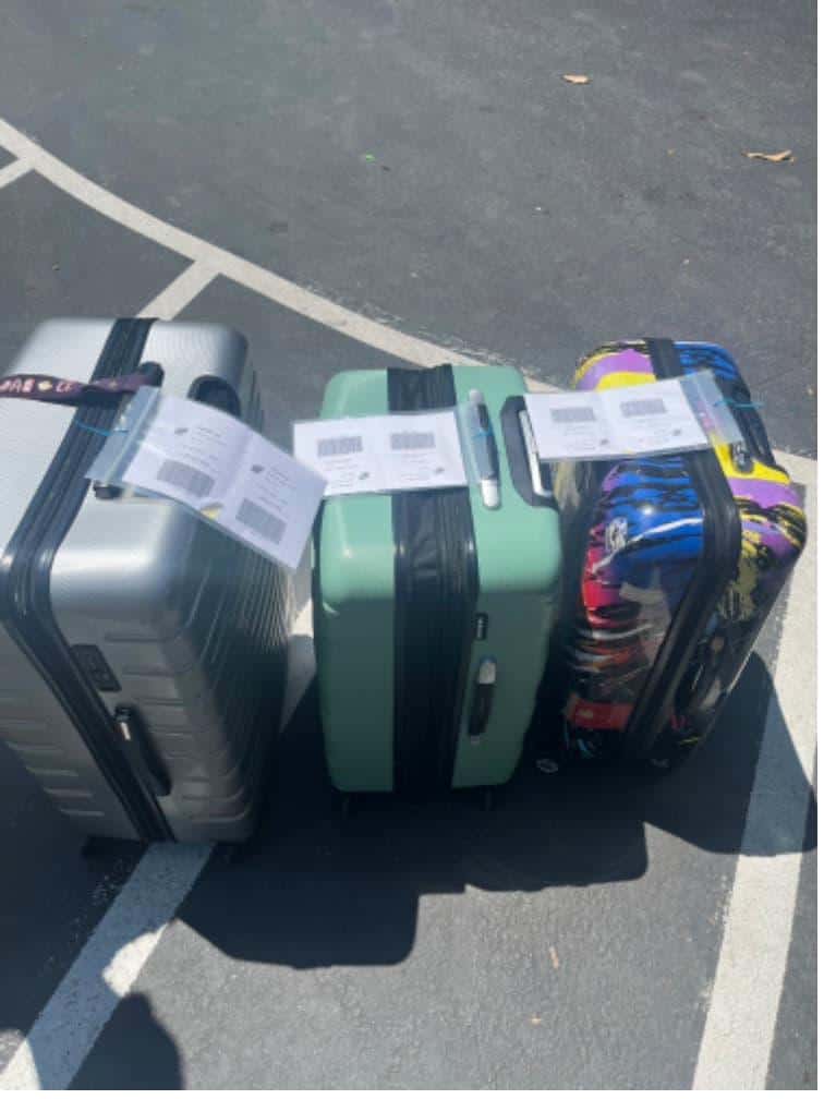 Student items including three colorful suitcases packed and labeled for claremont mckenna summer storage.