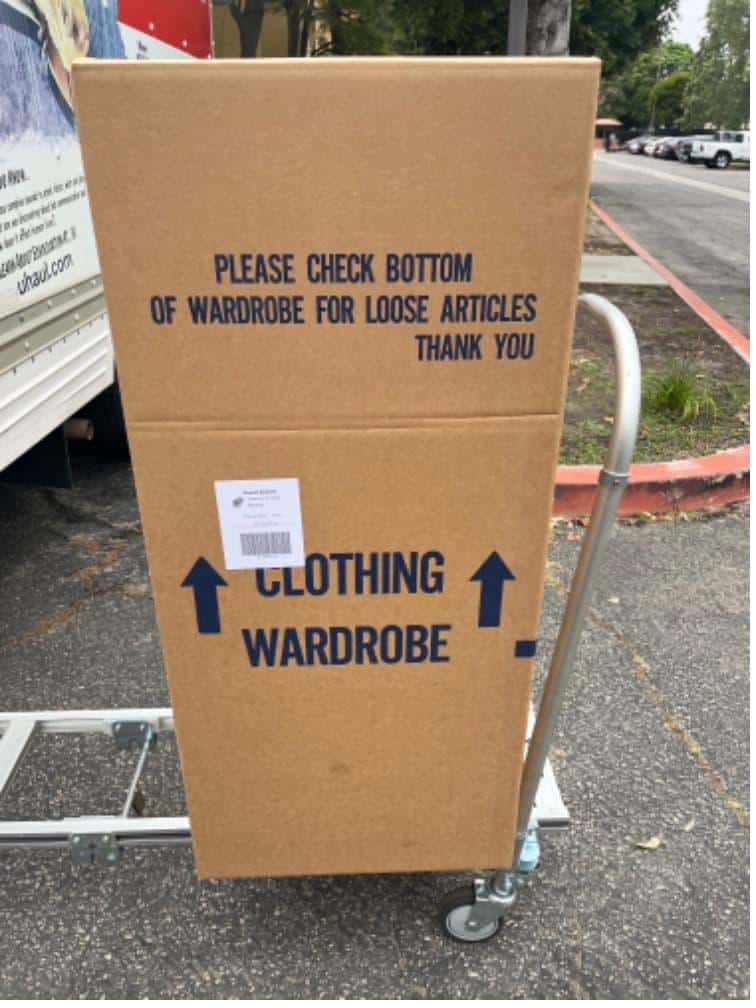 Student items including boxes and bins on a cart packed and labeled for student storage near Biola.