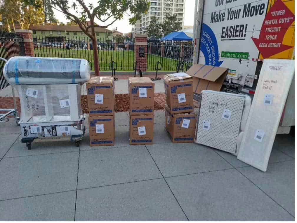 Student items including boxes near a mini fridge packed and labeled for student storage near Oxy.
