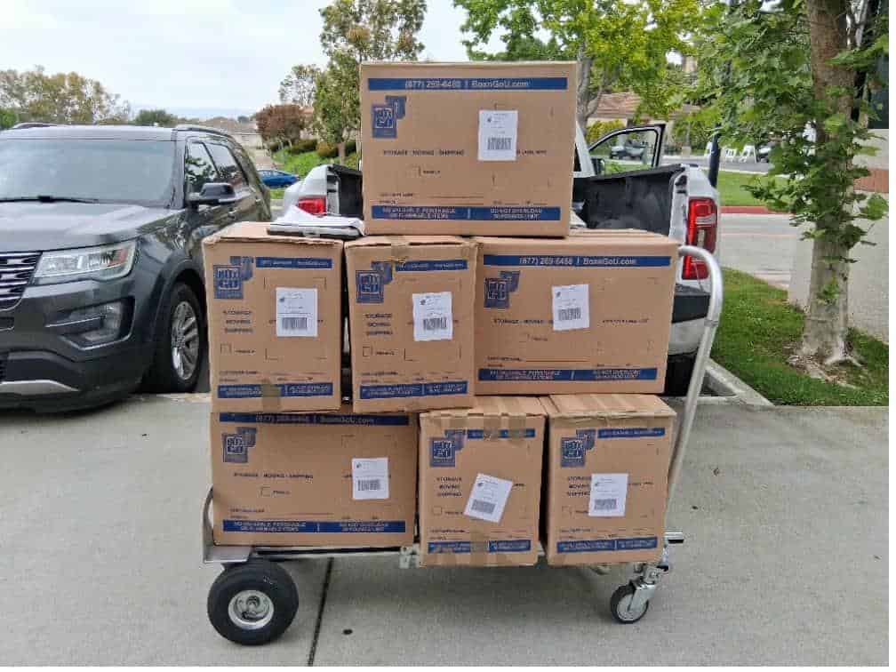 Student items including three stacked bins packed and labeled for Biola summer storage.