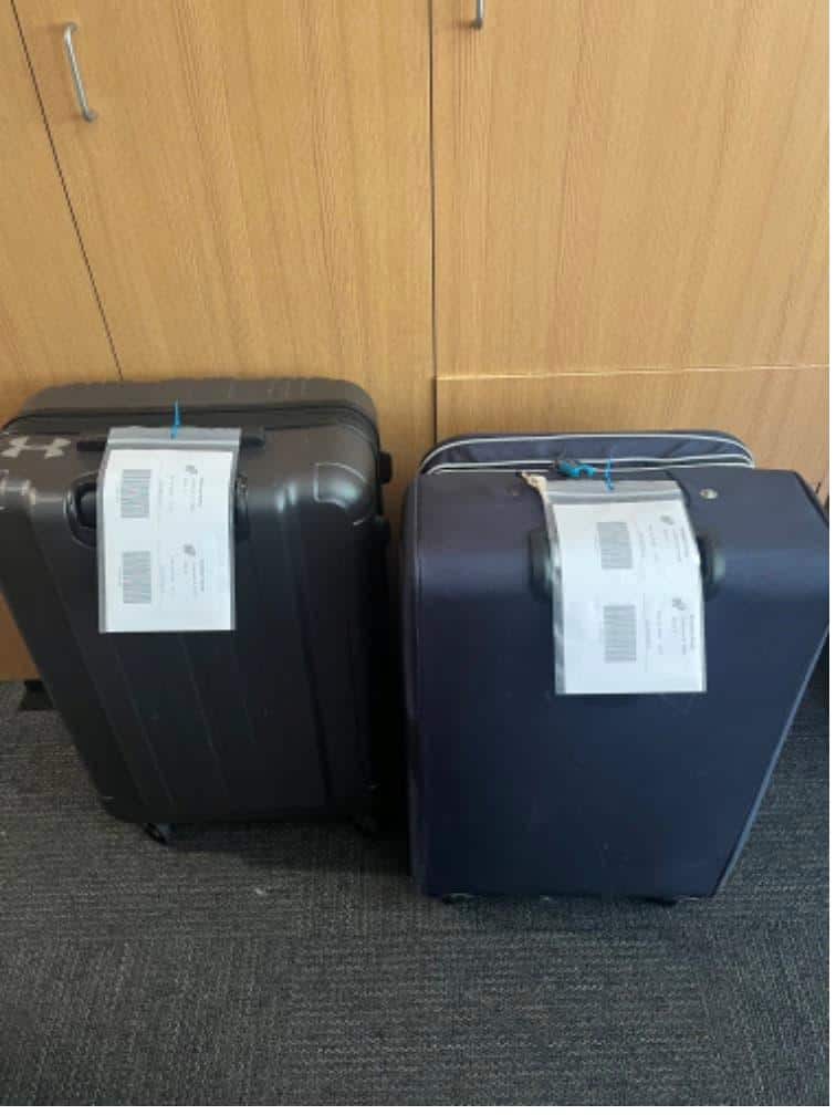 Student items including two hardshell suitcases packed and labeled for Dorm storage solutions near Claremont Colleges.