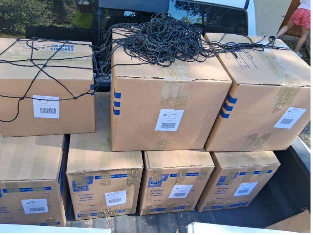 Student items including boxes with cargo net packed and labeled for Summer storage near Harvey Mudd College.