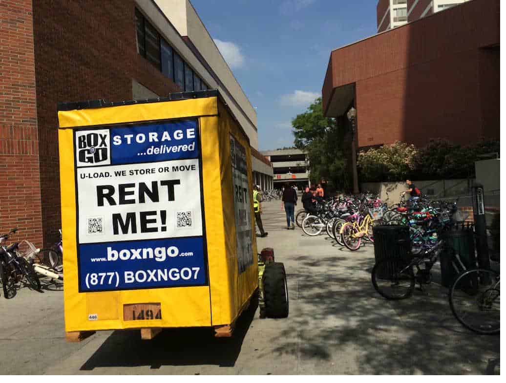 Yellow Box-n-Go university of la verne student storage container in a parking lot near the cones.