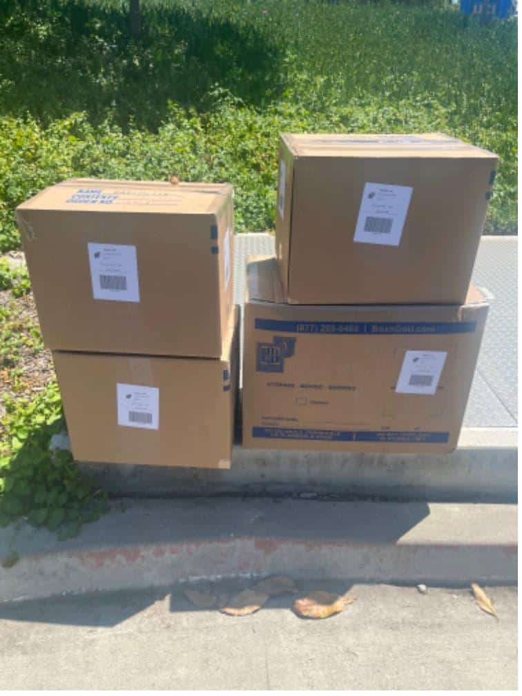 Student items including four labeled boxes packed and labeled for usc storage units.