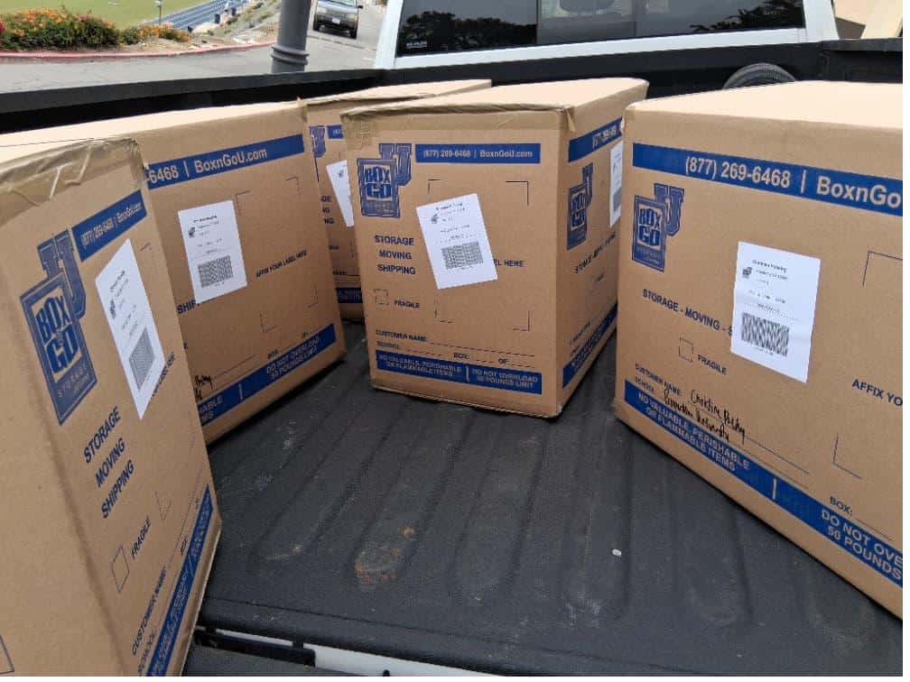 Student items including a tall stack of boxes packed and labeled for cal poly student storage.