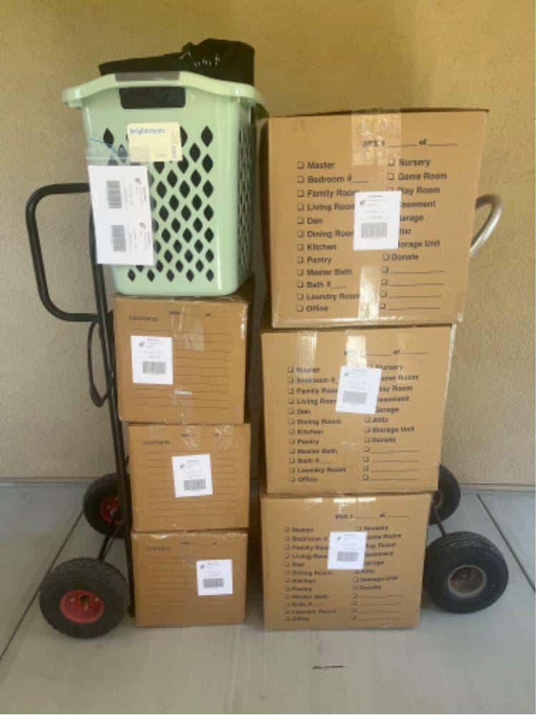 Student items including boxes on a hand truck packed and labeled for chapman summer storage.