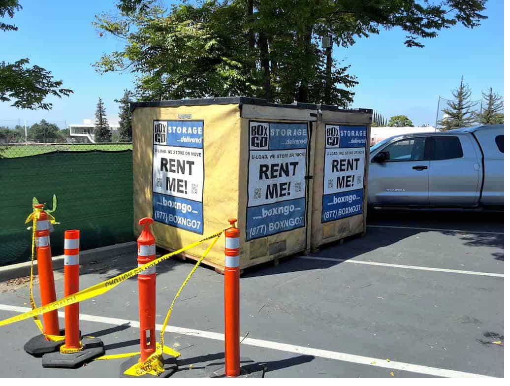 Yellow Box-n-Go Pitzer College summer storage container in a walkway near the columns.