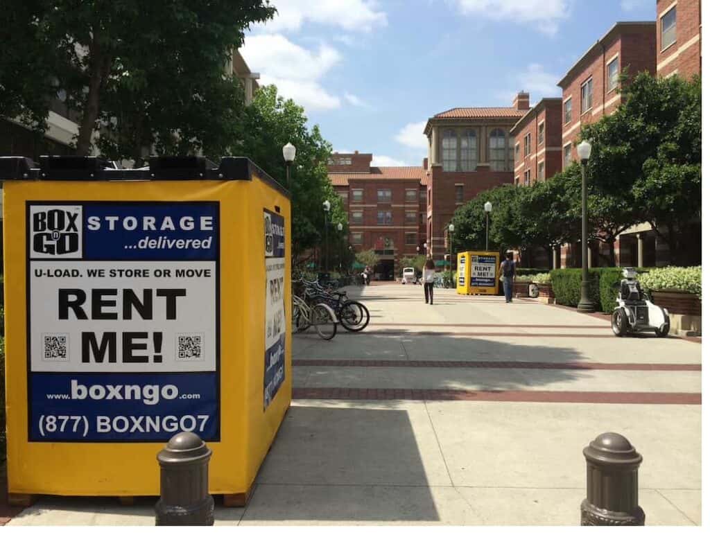 Yellow Box-n-Go container for student storage units faq on a campus with bikes