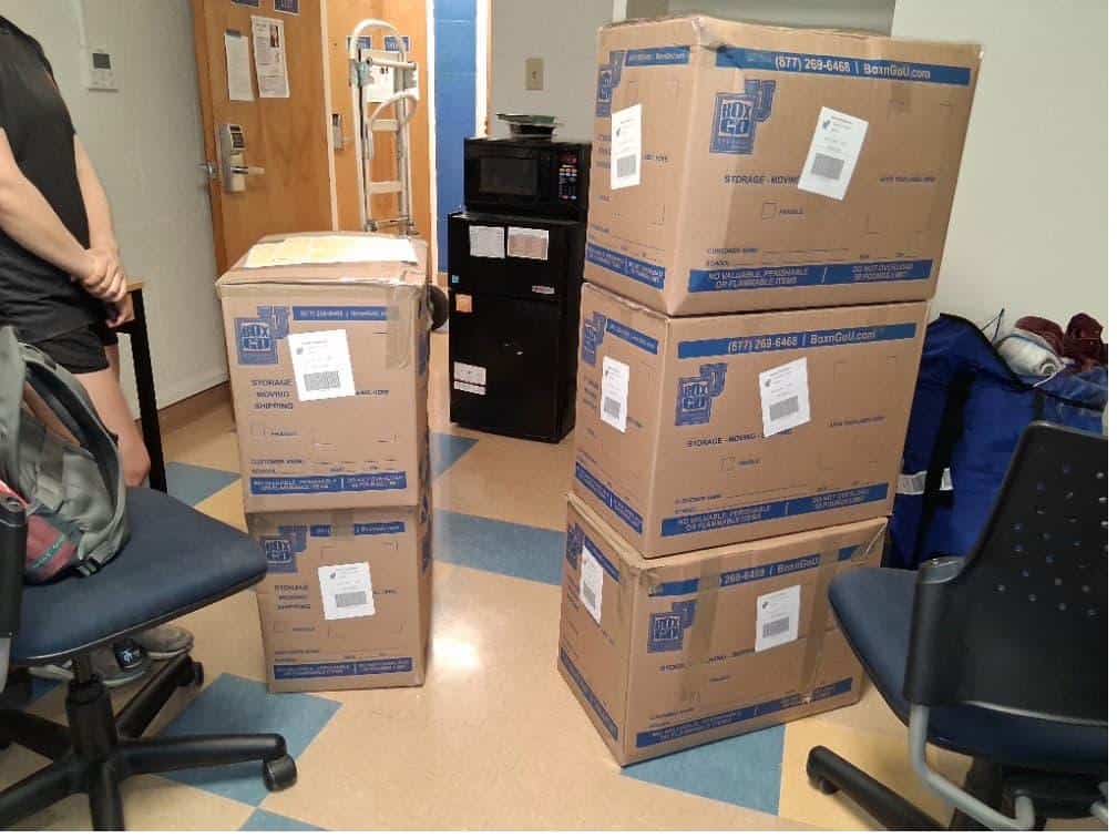 Student items including a wire organizer packed and labeled for dorm move out packing tips.