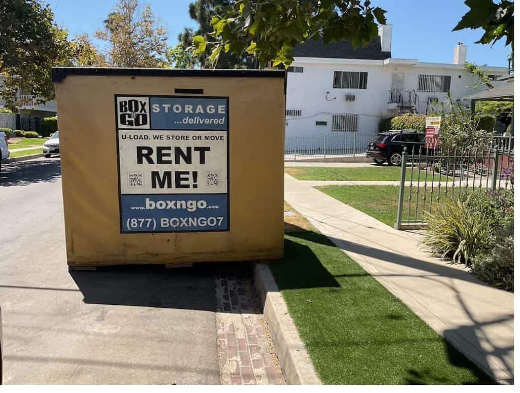 Box-n-Go Flex storage container placed curbside at an apartment building, showing tight-footprint delivery