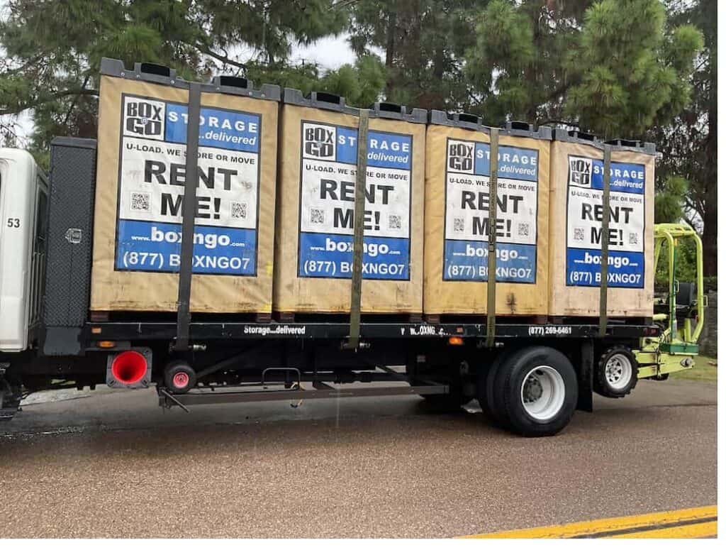 Box-n-Go flatbed truck loaded with four 8 by 5 foot Flex storage containers ready for residential delivery